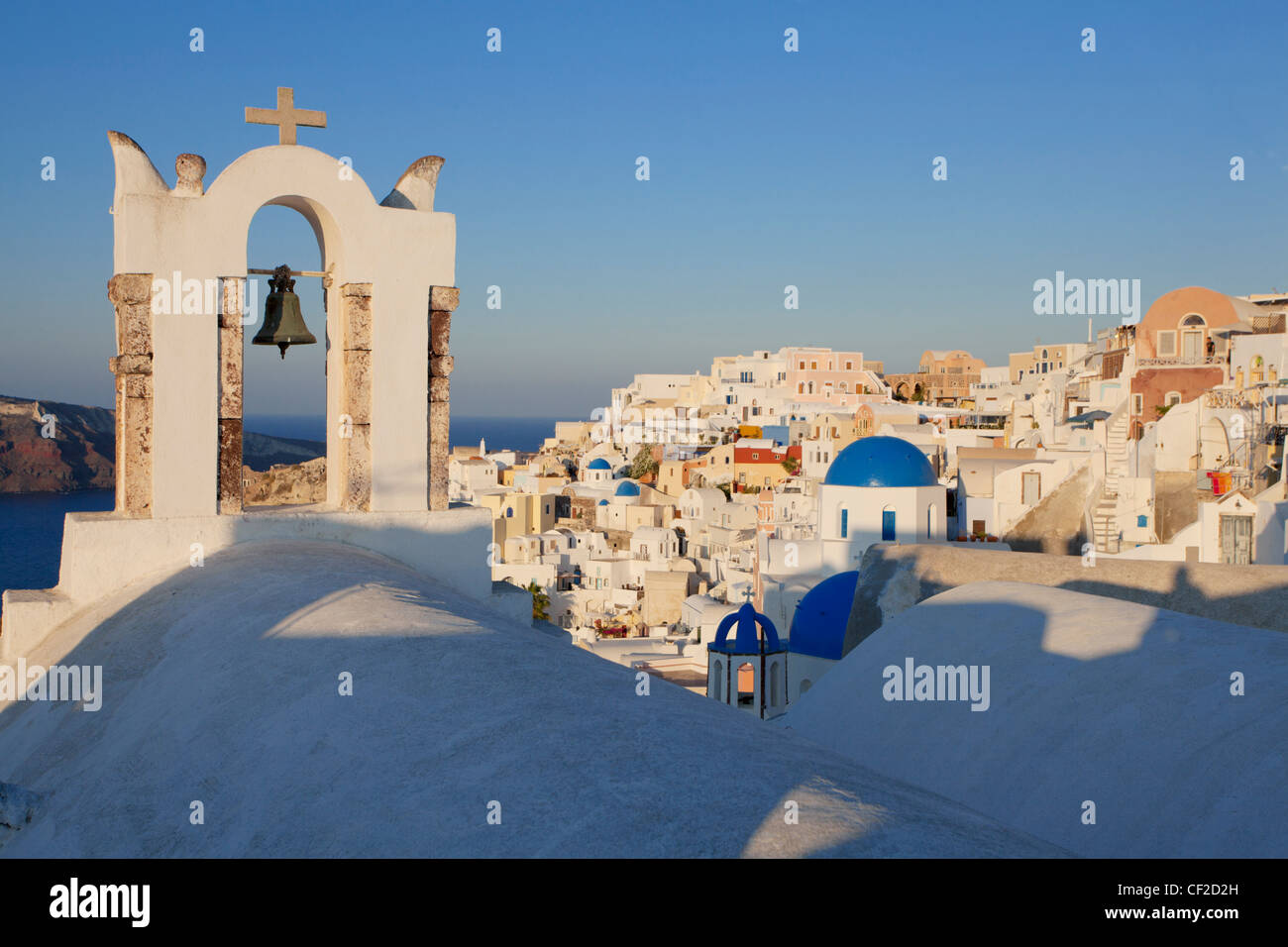 Vue du village d'Oia au lever du soleil avec un clocher à l'avant-plan Banque D'Images