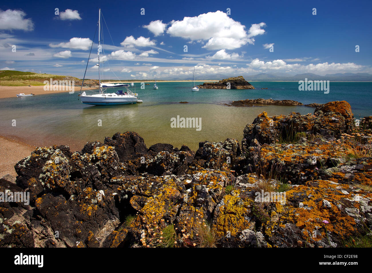 Yachts amarrés dans une baie sur l'île Llanddwyn, une île à marée coupée du continent à marée haute. Banque D'Images