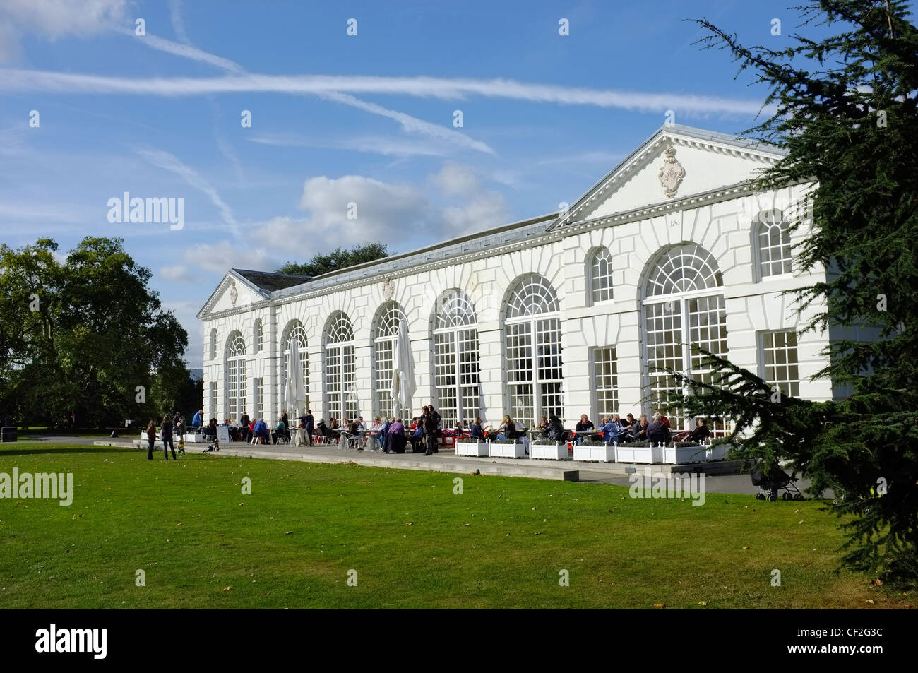 Les personnes mangeant à l'extérieur de l'Orangerie au Royal Botanic Gardens de Kew. Banque D'Images