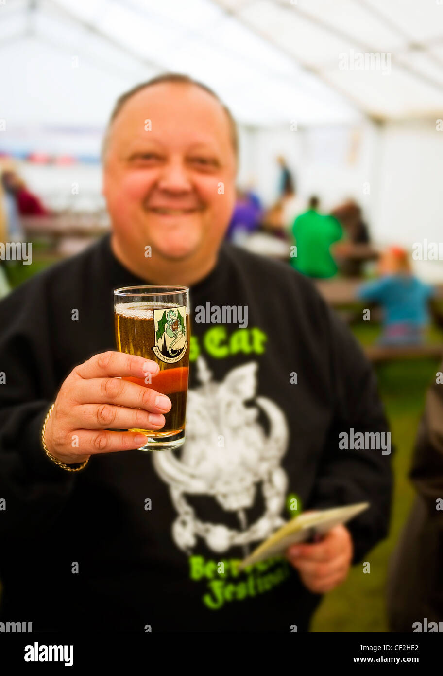 Un homme tenant une pinte d'ale réel à l'intérieur d'un chapiteau au Hoop Beer Festival. Banque D'Images