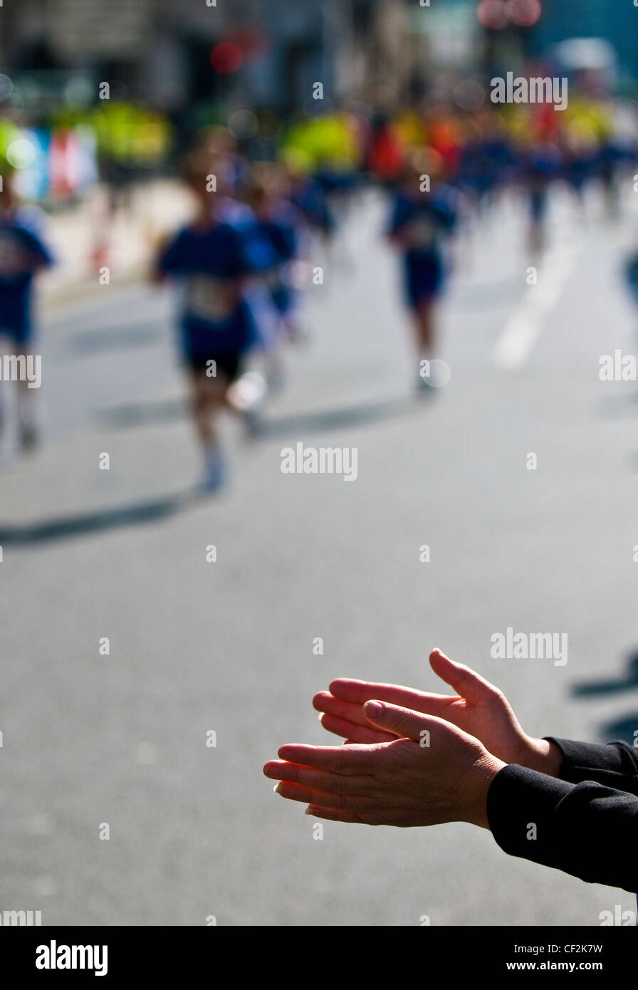 Un spectateur applaudir les coureurs participant à la marathon de Londres. Banque D'Images