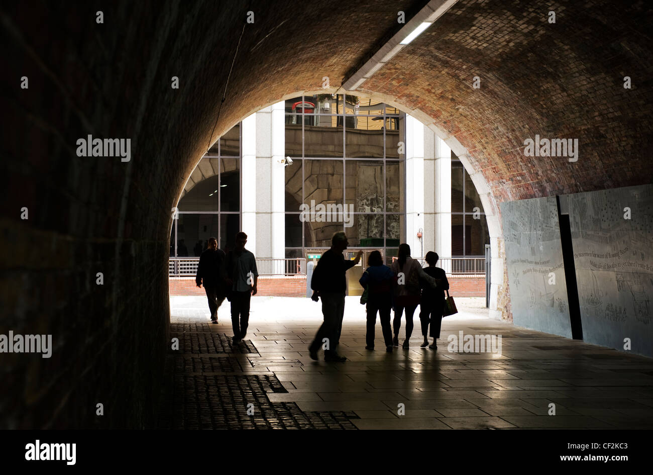 La silhouette de personnes marchant à travers un tunnel sur le chemin de la Tamise à Londres. Banque D'Images