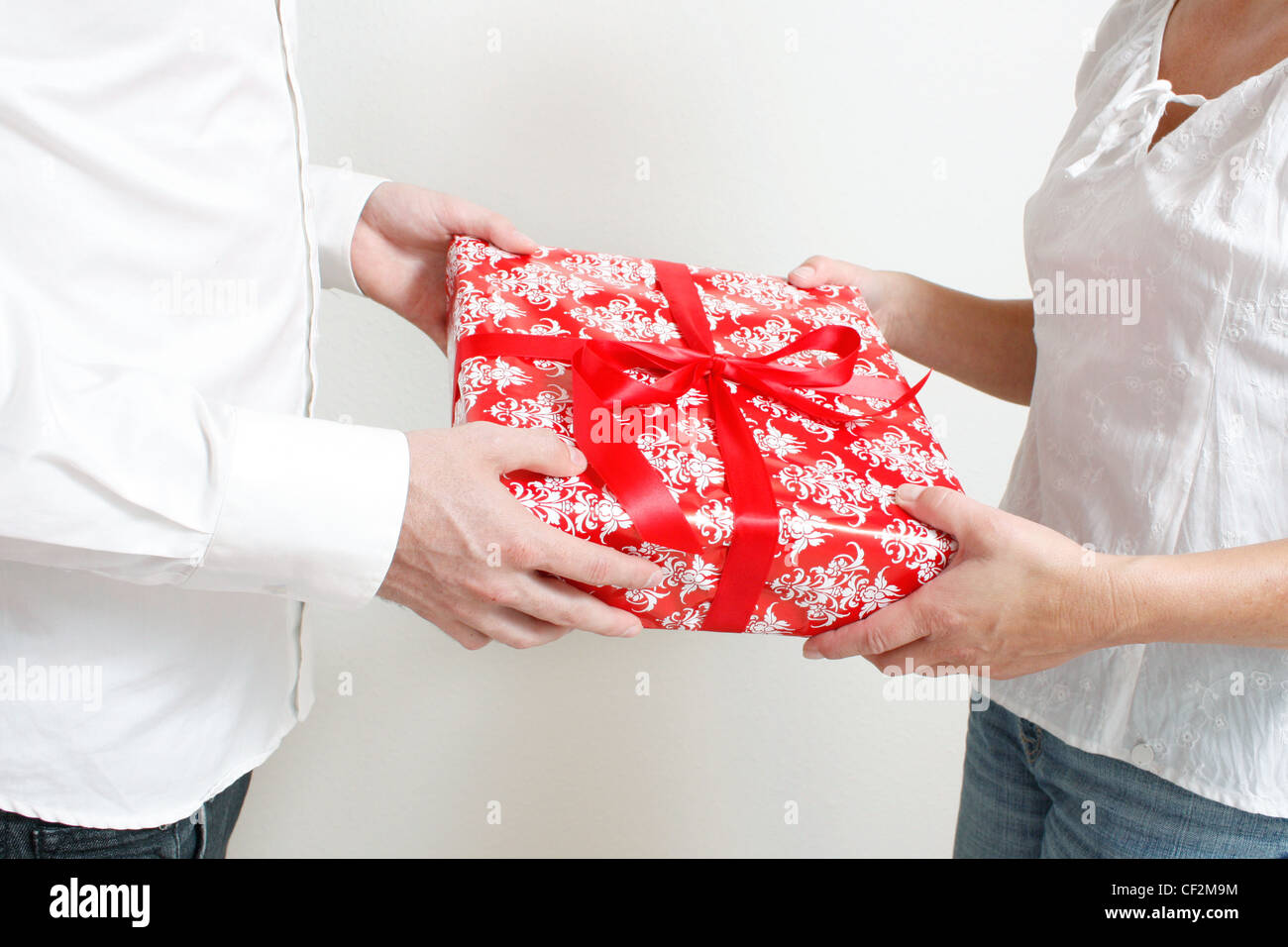 Un homme donnant à un cadeau de Noël à une femme Banque D'Images