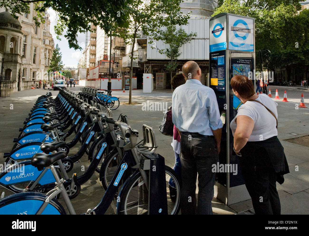 La lecture d'informations sur les touristes Barclays Cycle Hire Scheme sur un terminal à une station d'accueil. Banque D'Images