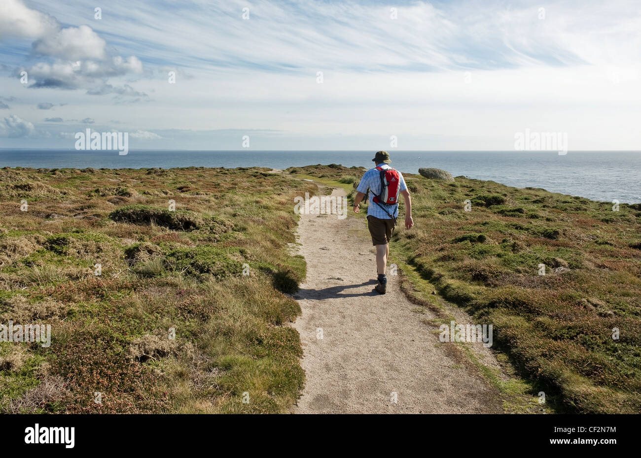 Un marcheur sur le chemin côtier du sud-ouest dans la région de Cornwall. Banque D'Images