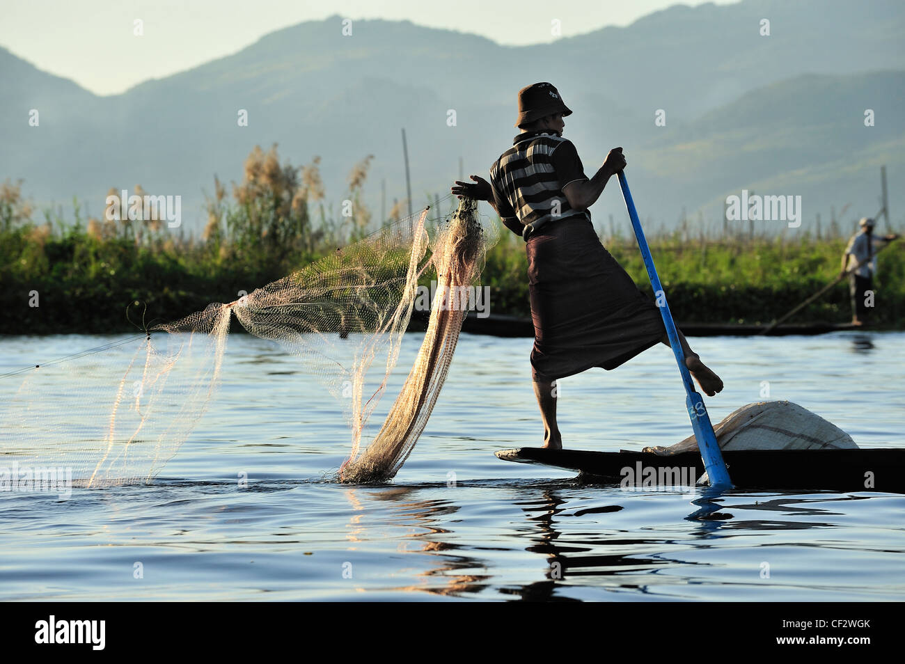 En début de soirée et la pêche sur le lac Inle avec une jambe l'aviron Banque D'Images