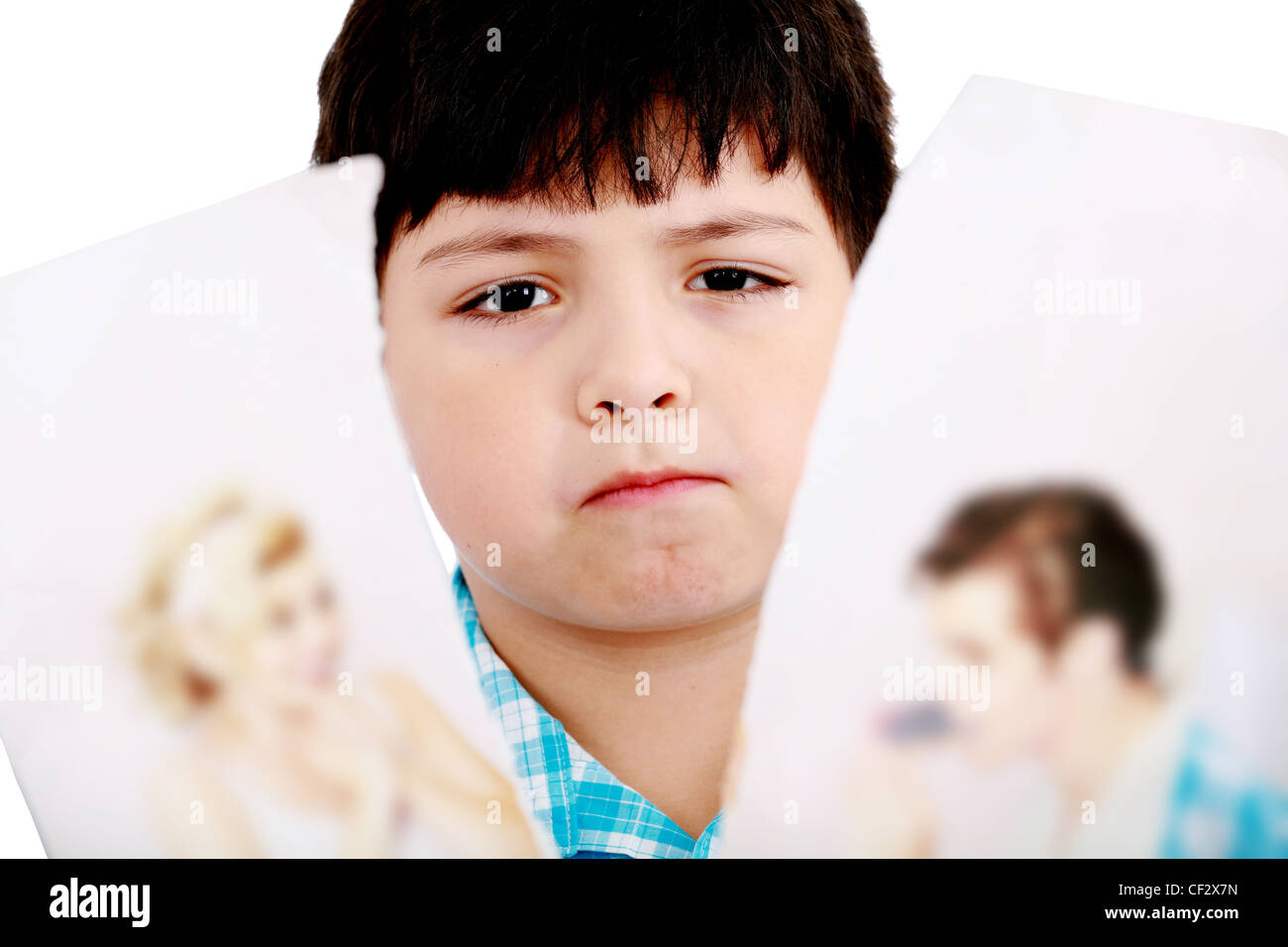 Fâché garçon debout en face pcture de parents avec des problèmes contre fond blanc Banque D'Images