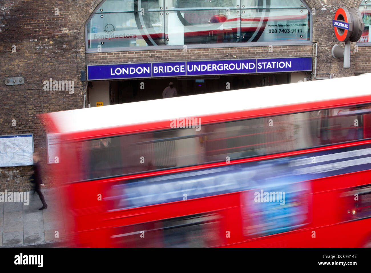 Vue d'un rouge traditionnel bus Londres comme il passe la station de métro London Bridge Banque D'Images