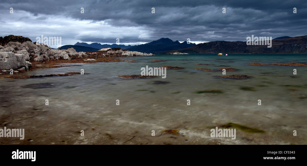 Une vue panoramique à partir de la rive vers un petit bateau amarré sur le Loch Eishort sur l'île de Skye. Banque D'Images