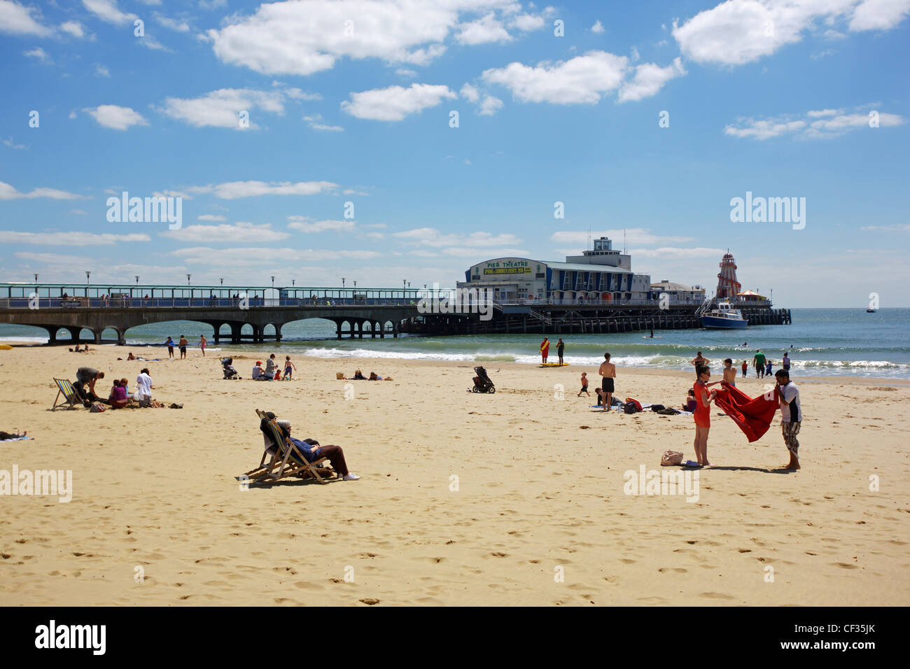 Les gens se détendre sur la plage de sable le long de la jetée de Bournemouth. Banque D'Images