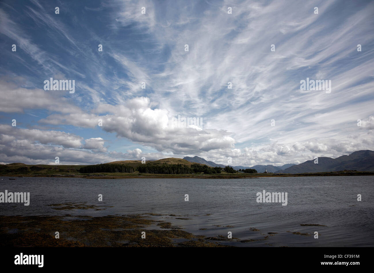 Donnant sur l'eau pour les montagnes lointaines sur l'île de Ornsay. Banque D'Images