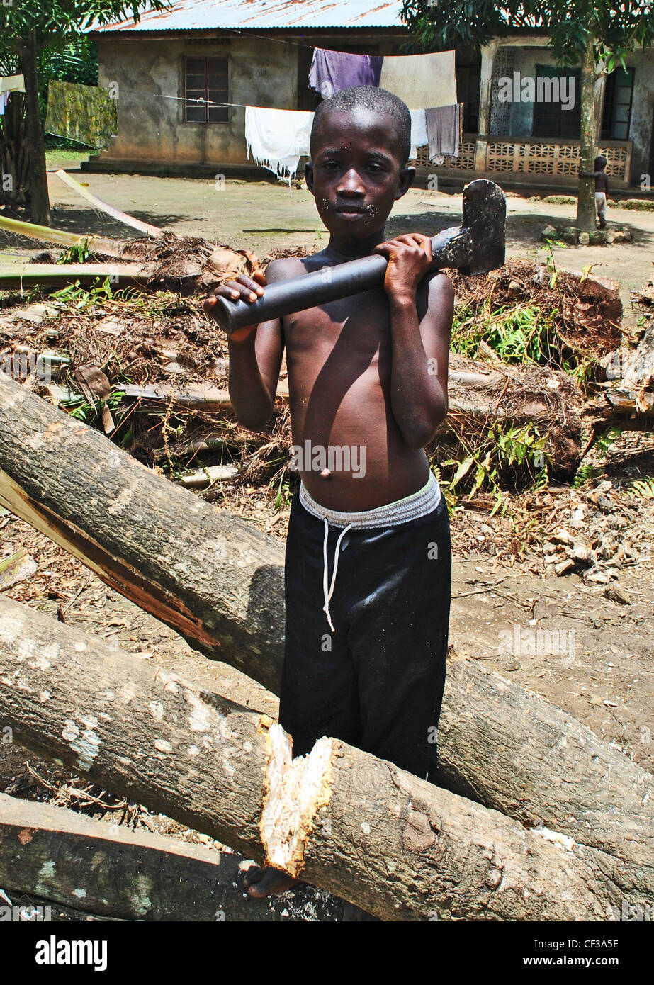 Un enfant de couper du bois pour combustible à Kenema, Sierra Leone Banque D'Images