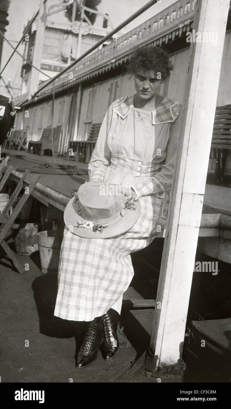 Femme debout sur le pont du bateau pendant la fin des années 1800 ou au début des années 1900 fashion hat bottes en cuir noir chemise blanche avec des boutons Banque D'Images