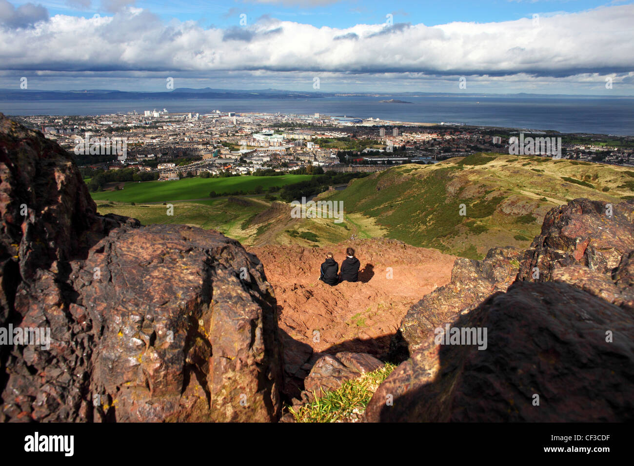 Deux femmes assis sur le siège d'Arthur en profitant de la vue sur Leith et le Firth of Forth. Banque D'Images