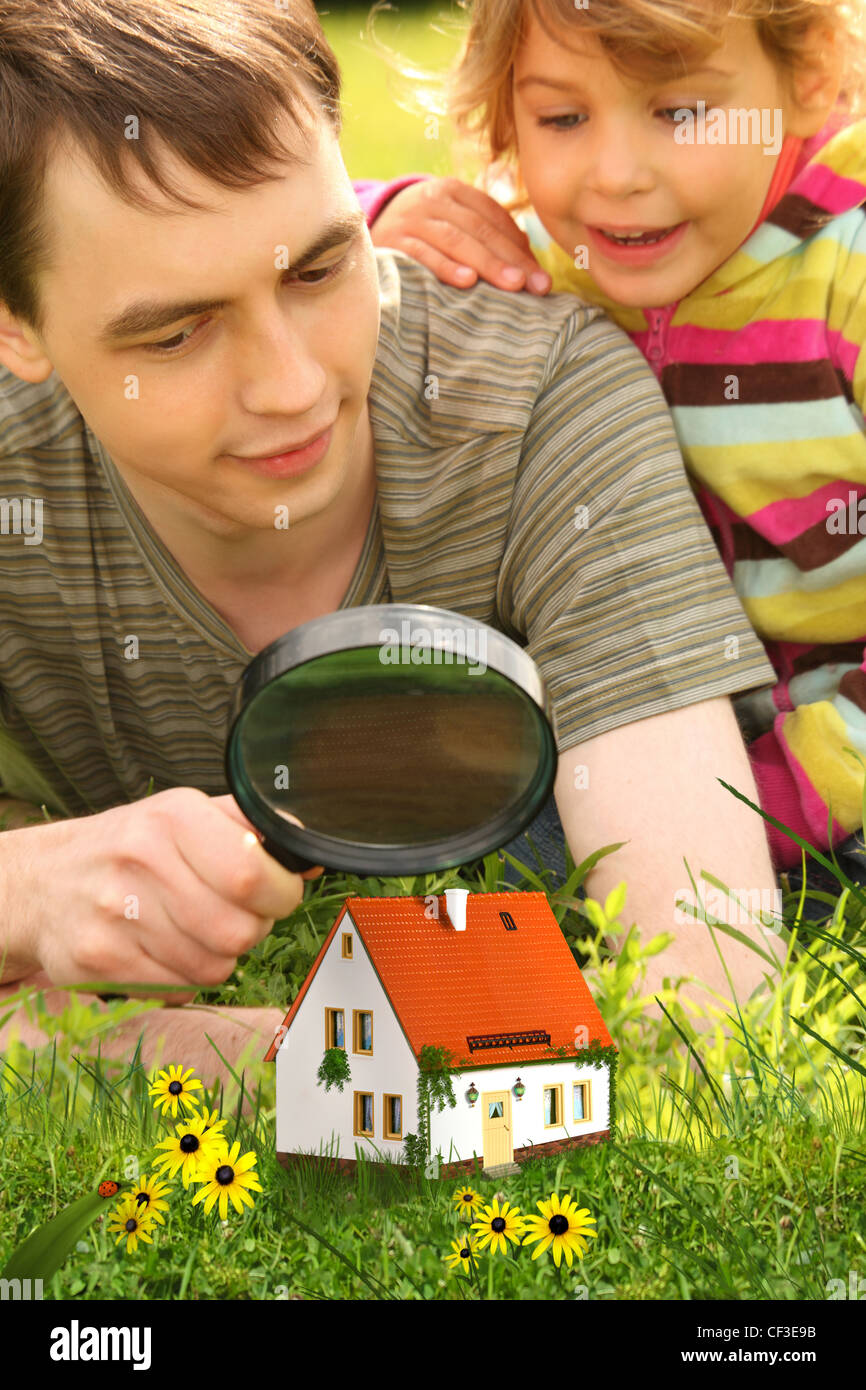 Père avec petite fille à la recherche sur les petites maison par collage loupe Banque D'Images