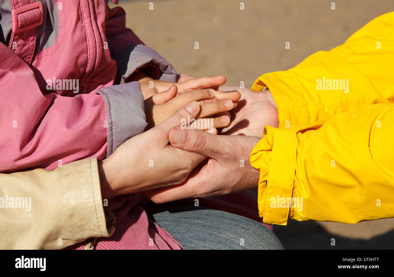 Organisation des mains de l'adulte et l'enfant comme symbole de l'unité familiale. Photo à l'extérieur. Banque D'Images