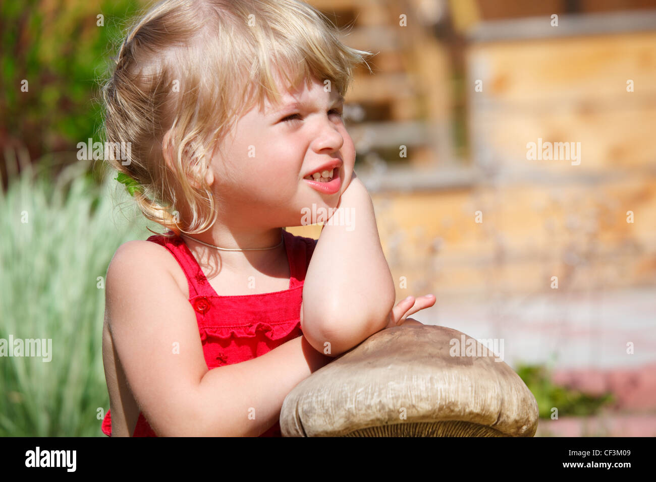 Portrait de petite fille sur la pelouse ensoleillée le jour Banque D'Images