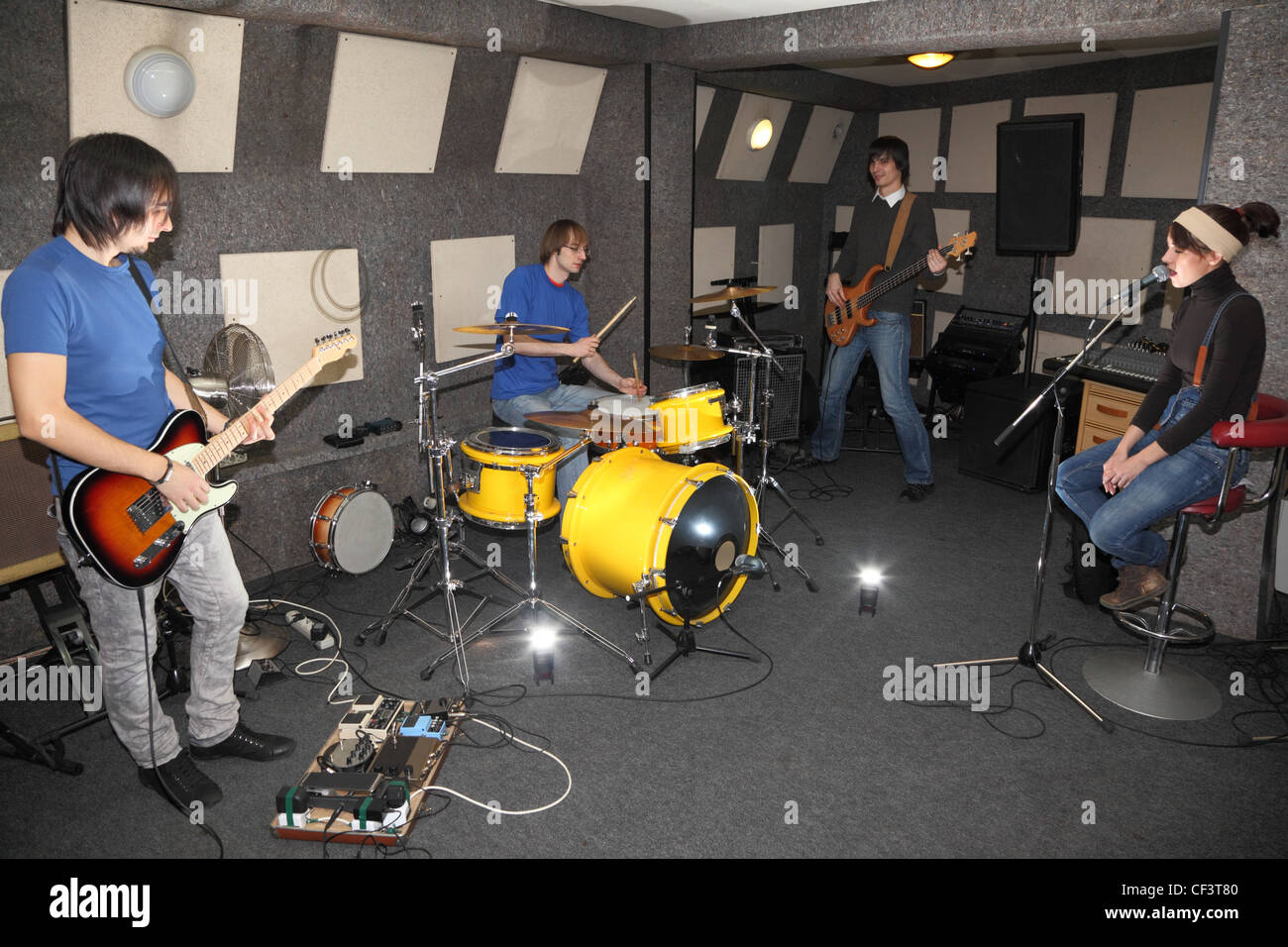 Un groupe de rock. chanteur girl, deux musiciens avec guitares électro et un batteur de studio de travail. clignote dans le centre Banque D'Images