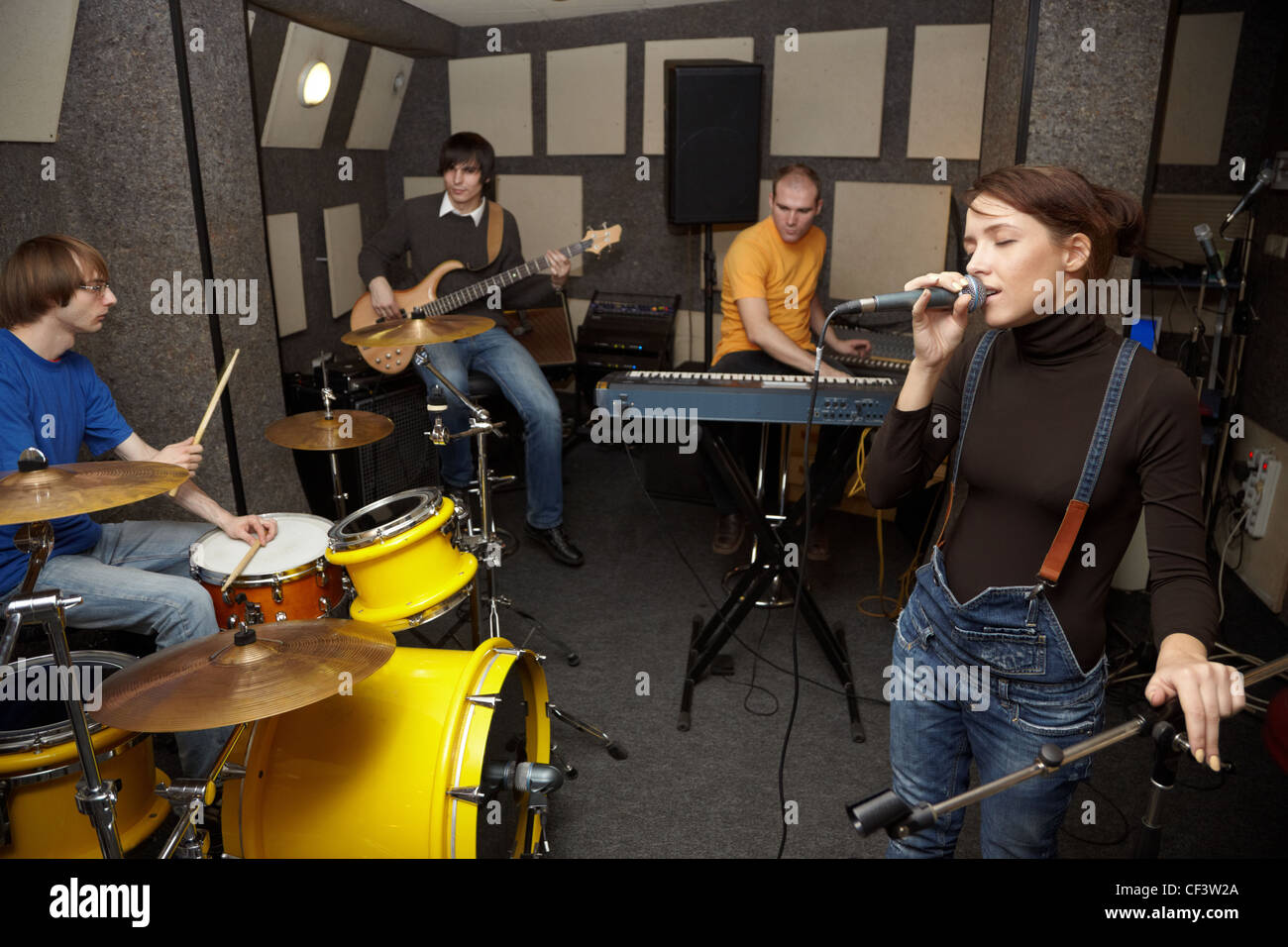 Un groupe de rock travaillant en studio. chanteur fille chante. L'accent sur clothers fille du chanteur Banque D'Images