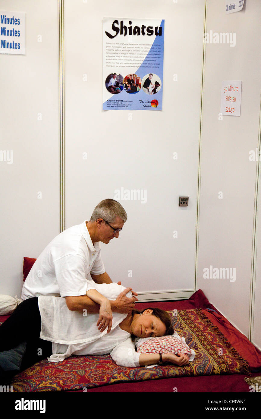 Un thérapeute shiatsu massage donnant à une femme, la douleur dorsale show, London UK 2012 Banque D'Images