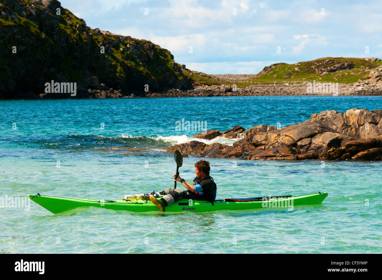 Un homme kayak hors de Camas Bostadh sur Great Bernera dans les Hébrides extérieures. Banque D'Images