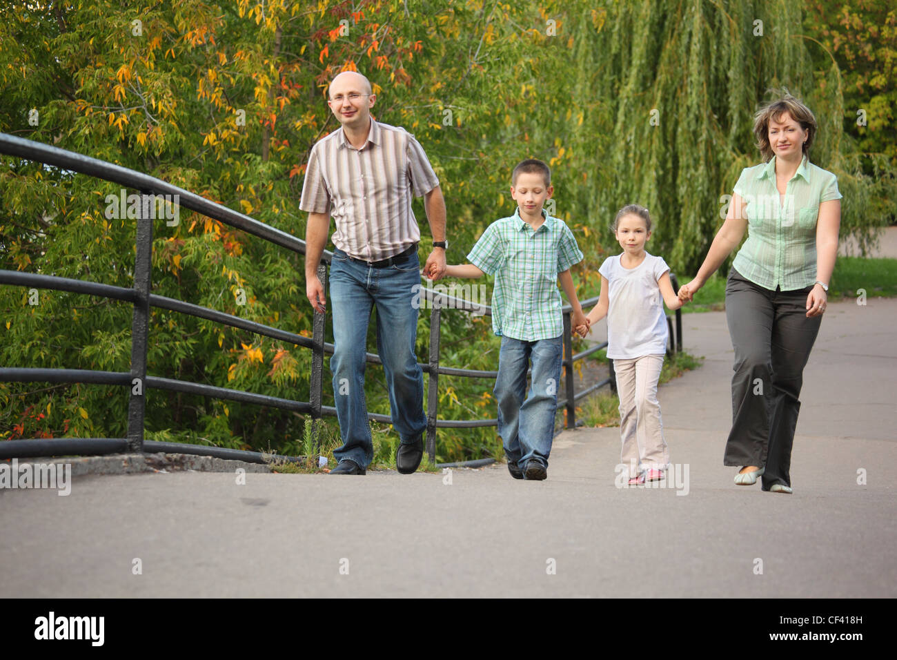 Famille avec deux enfants est handies sur un pont et la marche Banque D'Images