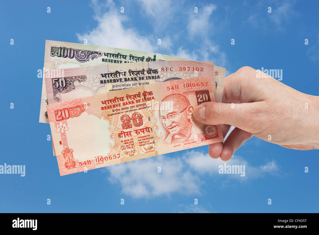 Un 20. un 50 et un 100 Indian Rupee factures avec le portrait du Mahatma Gandhi est tenue à la main. Ciel est dans l'arrière-plan Banque D'Images
