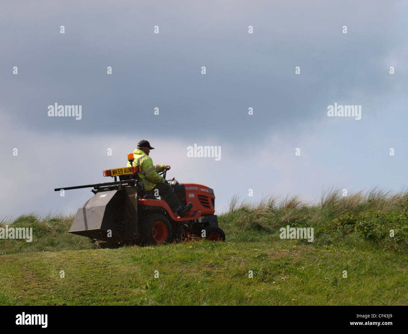 L'herbe de tonte travailleur du Conseil, Cornwall, UK Banque D'Images