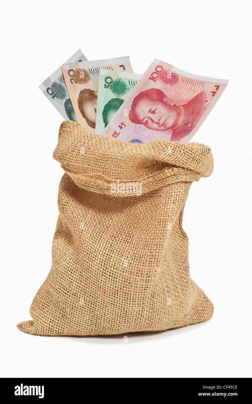 De nombreuses factures Yuan chinois avec le portrait de Mao Zedong sont dans un sac de jute. Le renminbi est la monnaie chinoise. Banque D'Images