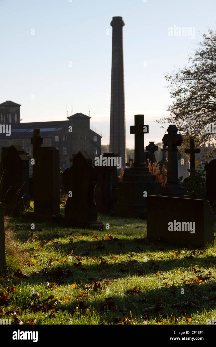 Le cimetière de la Sainte Église, Trinty Queensbury, West Yorkshire, avec la tour de digue noir Moulin dans l'arrière-plan. Banque D'Images