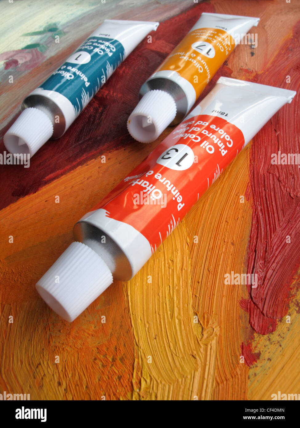 Tubes de rouge, bleu et jaune de la peinture à l'huile se trouvent sur le dessus d'une peinture à l'huile. Banque D'Images