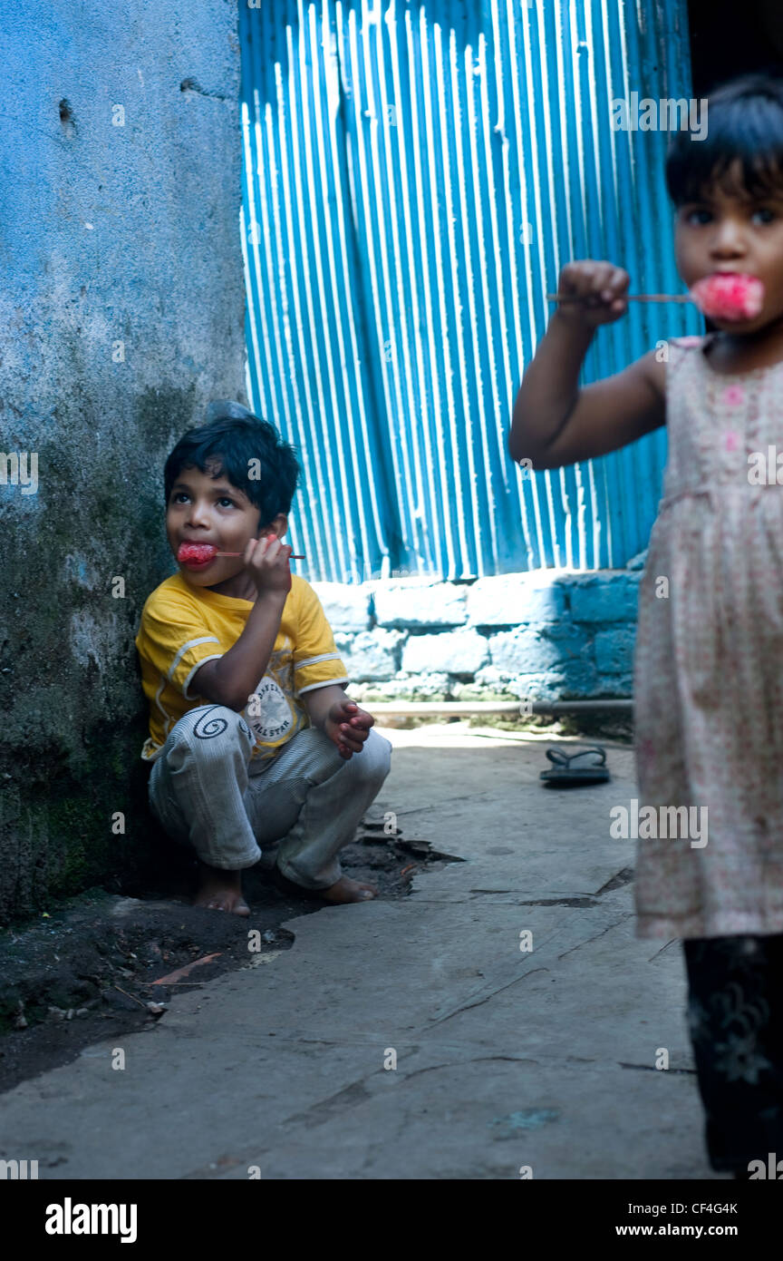 Les enfants ayant des sucettes glacées glace - Annawadi, Mumbai, Inde Banque D'Images