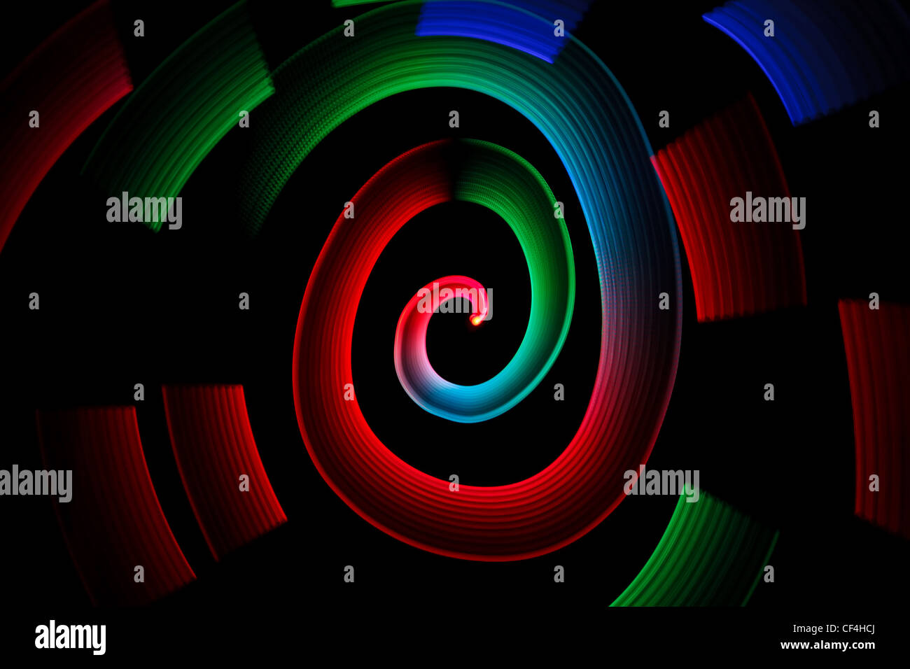 Résumé en spirale rougeoyante multicolores sur fond noir. Banque D'Images