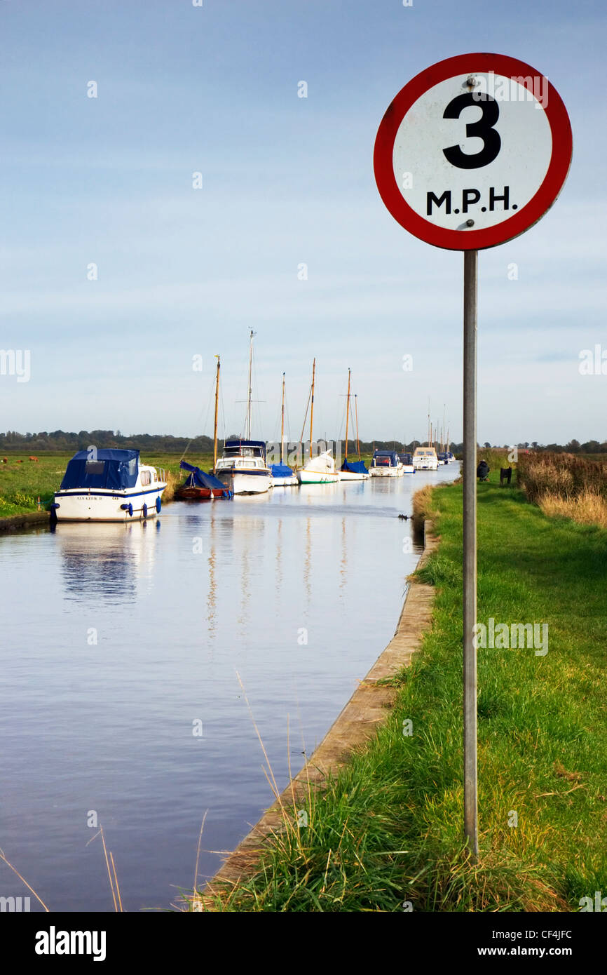 Une limite de vitesse maximale 3 mh signe sur les Norfolk Broads avec yachts amarrés dans l'arrière-plan. Banque D'Images