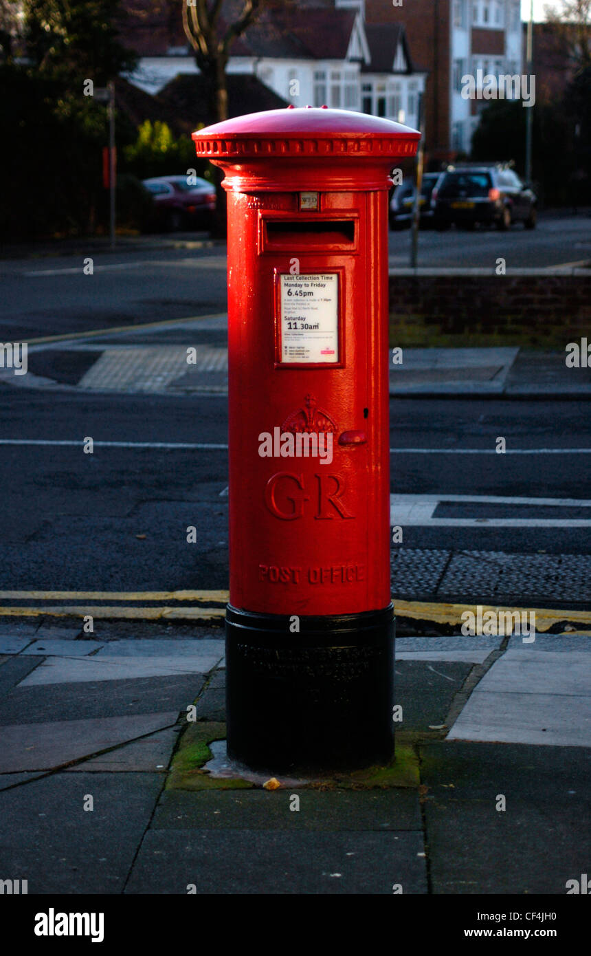 Boite aux lettres rouge classique sur un trottoir à Brighton. Banque D'Images