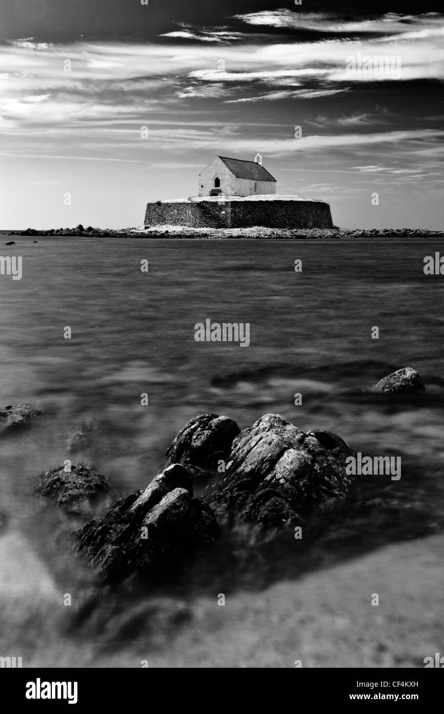 L'église St Cwyfan, connue comme l'Église dans la mer, sur une petite île appelée marée Cribinau au large de la côte d'Anglesey. Banque D'Images