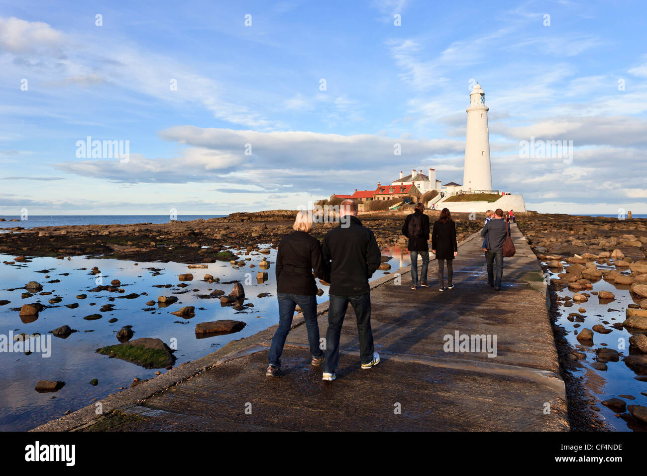 Les gens de marcher à travers la chaussée en béton à St Mary's Lighthouse près de Whitley Bay. Banque D'Images