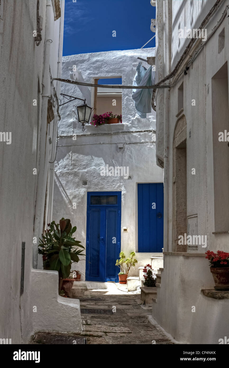 Cour avec portes bleues et des murs blancs dans les Pouilles, Italie Banque D'Images