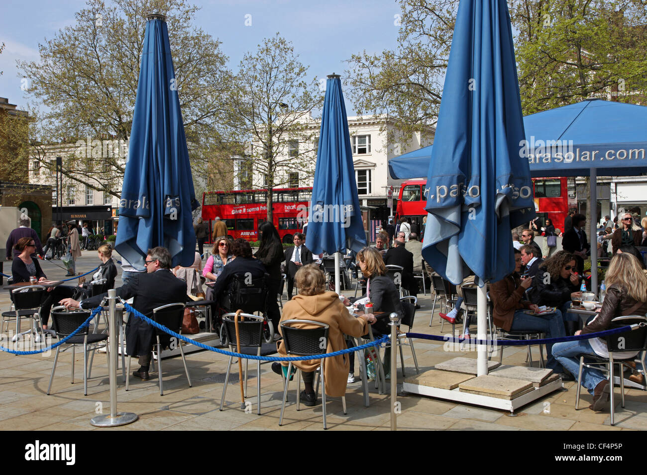 Les gens assis à des tables à la terrasse d'un café sur la King's Road à Chelsea. Banque D'Images
