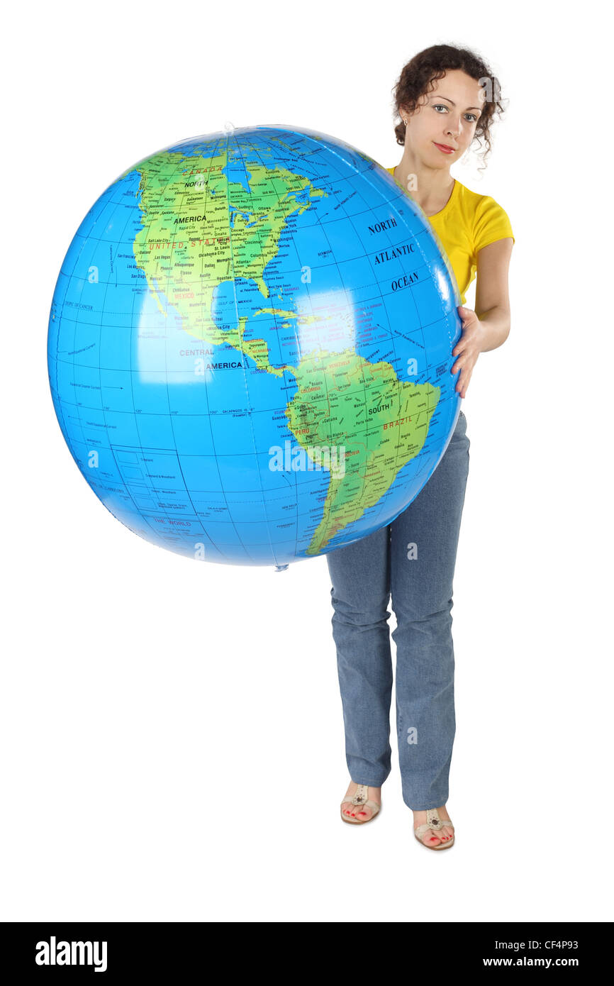 Jeune femme en chemise jaune curl holding big globe and looking at camera isolated on white Banque D'Images