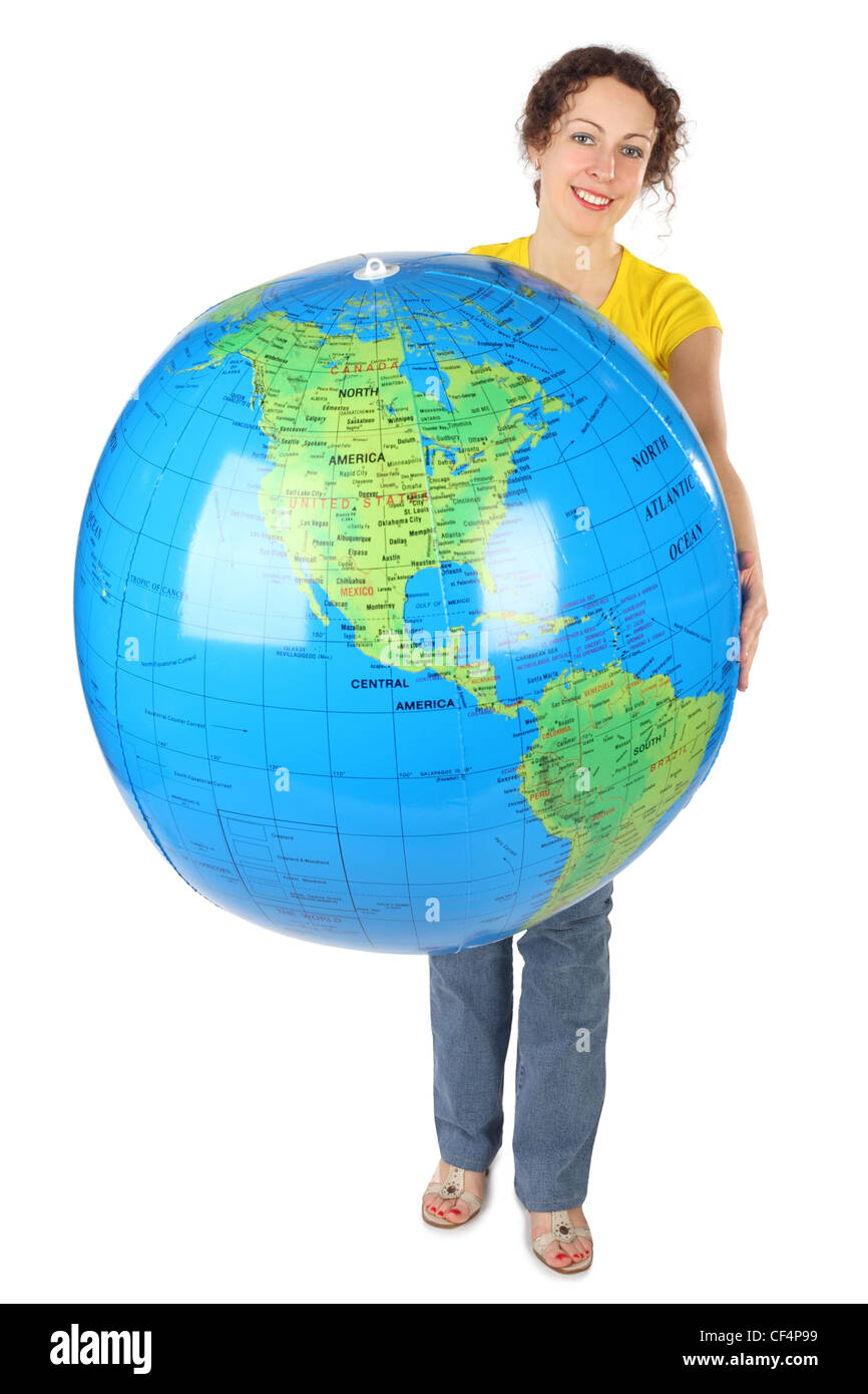 Jeune femme en chemise jaune curl holding big globe, smiling and looking at camera isolated on white Banque D'Images
