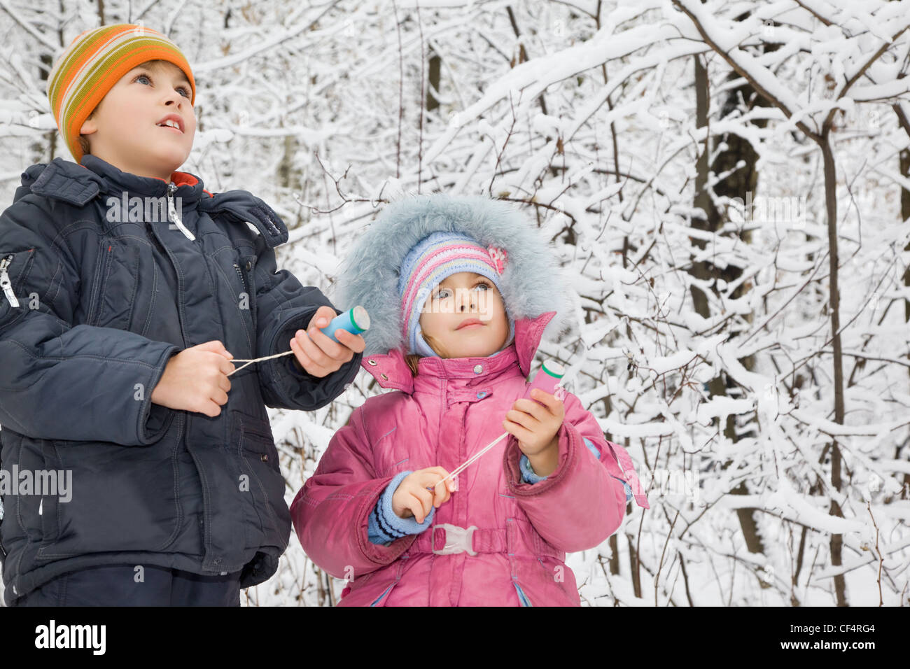 Garçon joyeux et petite fille avec piège à mains en hiver dans le bois Banque D'Images