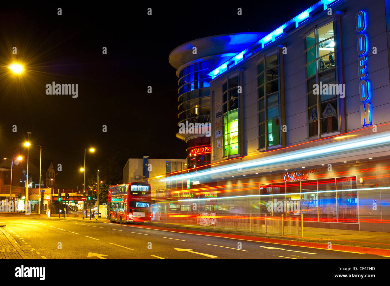 Des sentiers de lumière à partir d'un autobus à deux étages à l'extérieur du centre commercial la rotonde la nuit. Banque D'Images