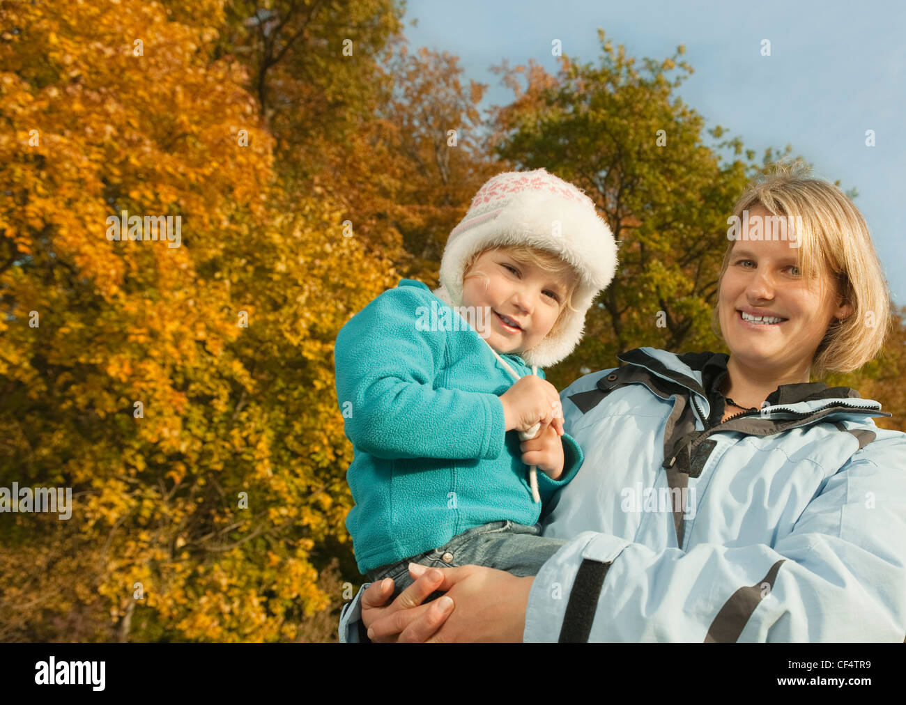 Germany, Bavaria, Mother carrying daughter smiling, portrait Banque D'Images