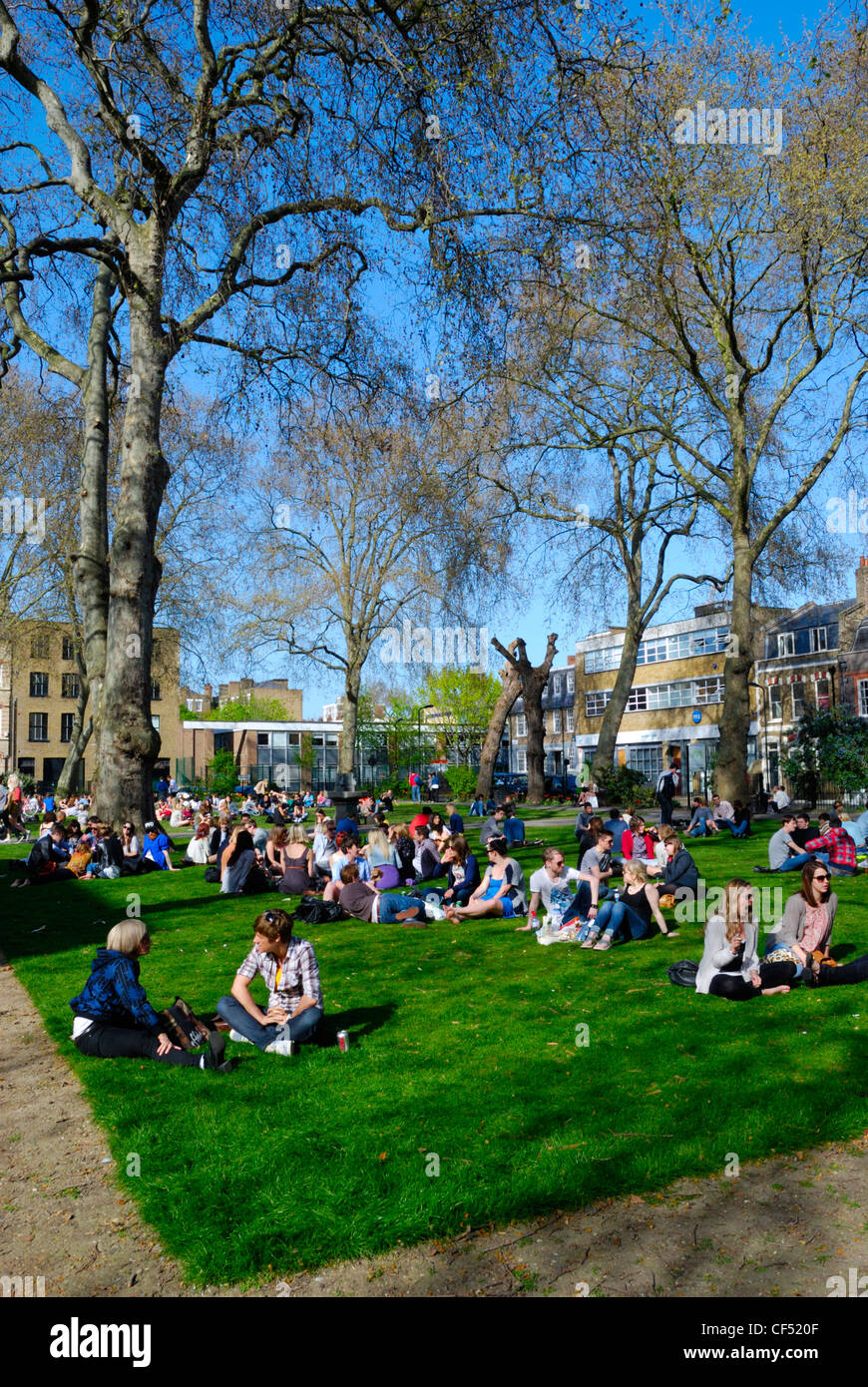 Les jeunes se détendre au soleil à Hoxton square. Banque D'Images