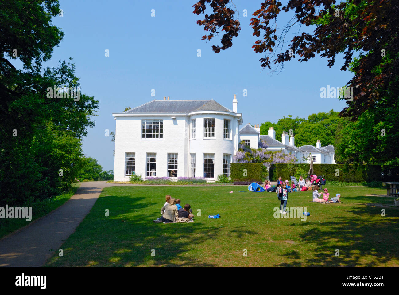 Les familles se détendre sur une pelouse par Pembroke Lodge, un manoir géorgien à Richmond Park. Banque D'Images