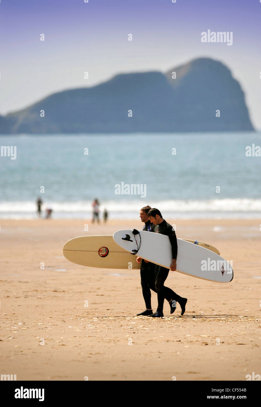 Les surfeurs le sable à Rhossili Bay sur la Gower, S. Wales (23 mai 2009). Banque D'Images