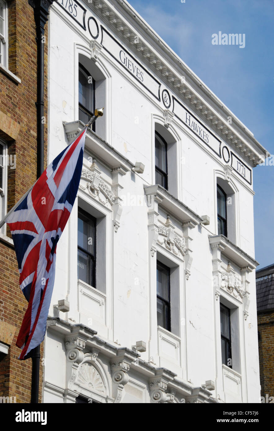 Un drapeau britannique est suspendu au-dessus Gieves Hawkes et tailleurs de Saville Row. Banque D'Images