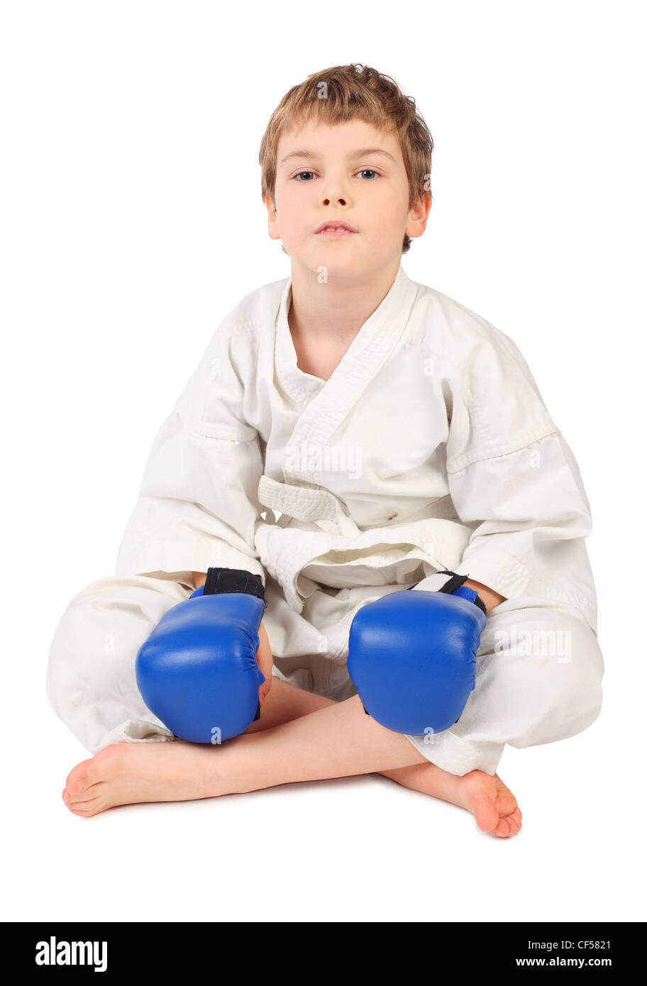 Petit garçon boxer en robe blanche et bleu gants de boxe assis isolated on white Banque D'Images