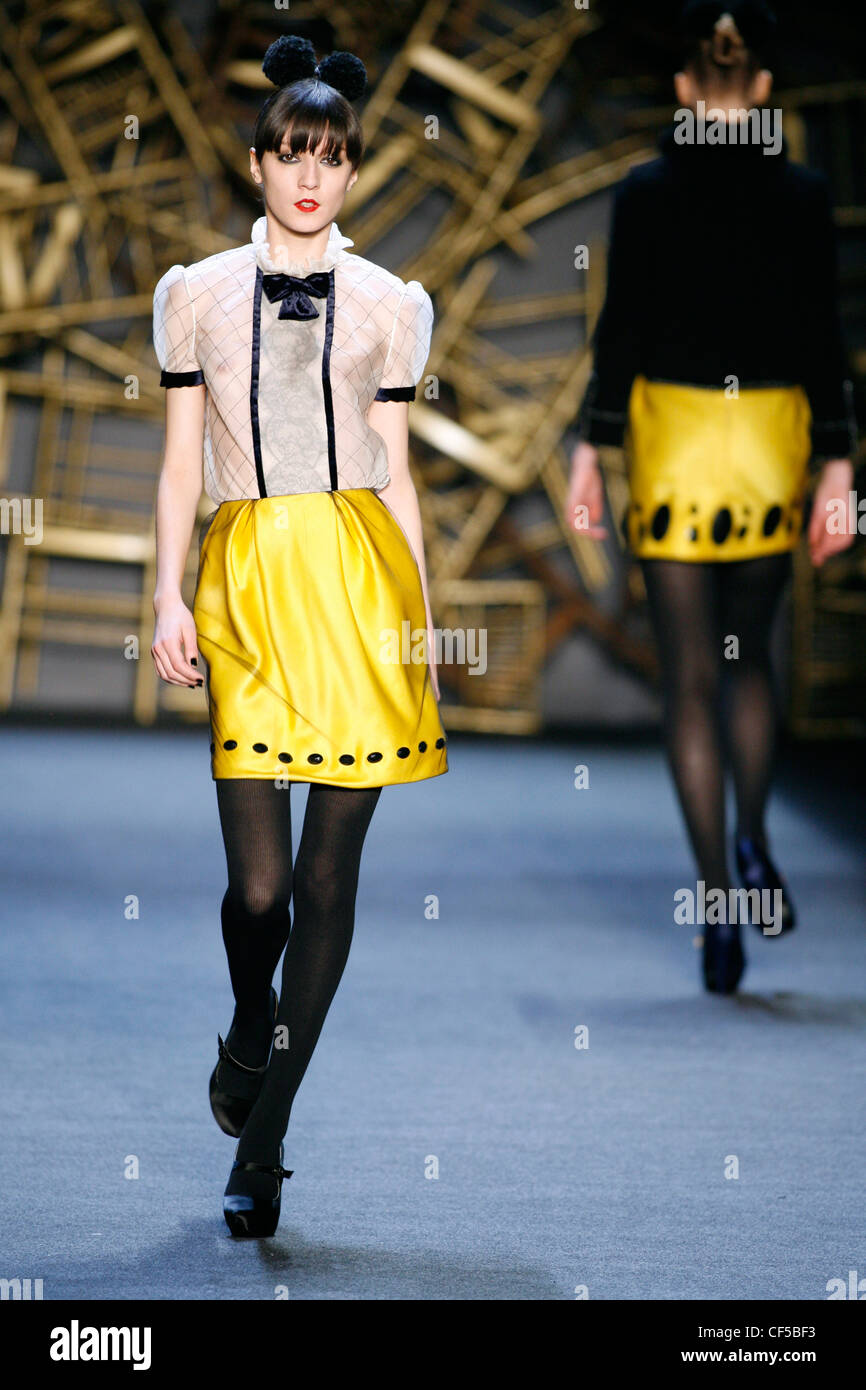 Chemisier blanc avec dentelle noire et vérifier à l'avant du cou, jupe de soie jaune vif Banque D'Images